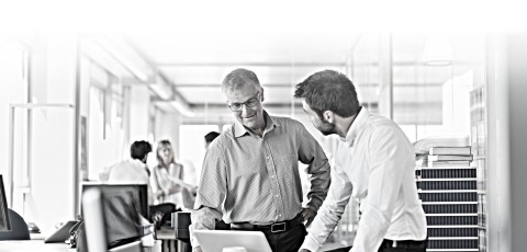 Two men discuss something while in an office.