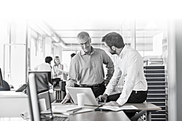 Two men discuss something while in an office.